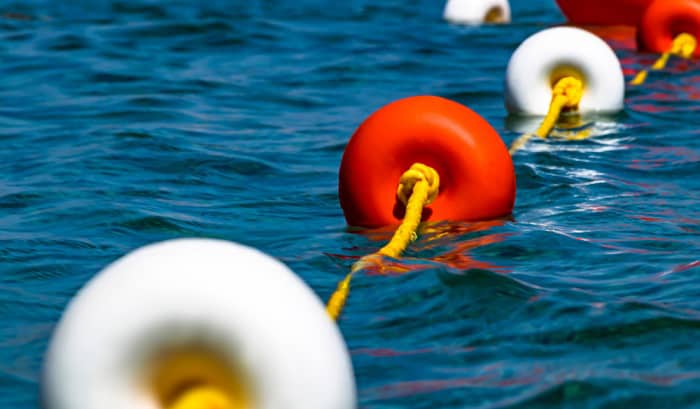 white-buoy-with-orange-markings-and-black-lettering